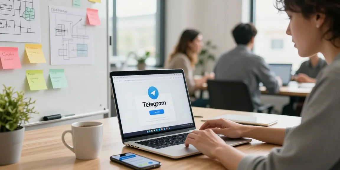 User accessing Telegram web version on a laptop in a modern collaborative workspace with colleagues in the background.